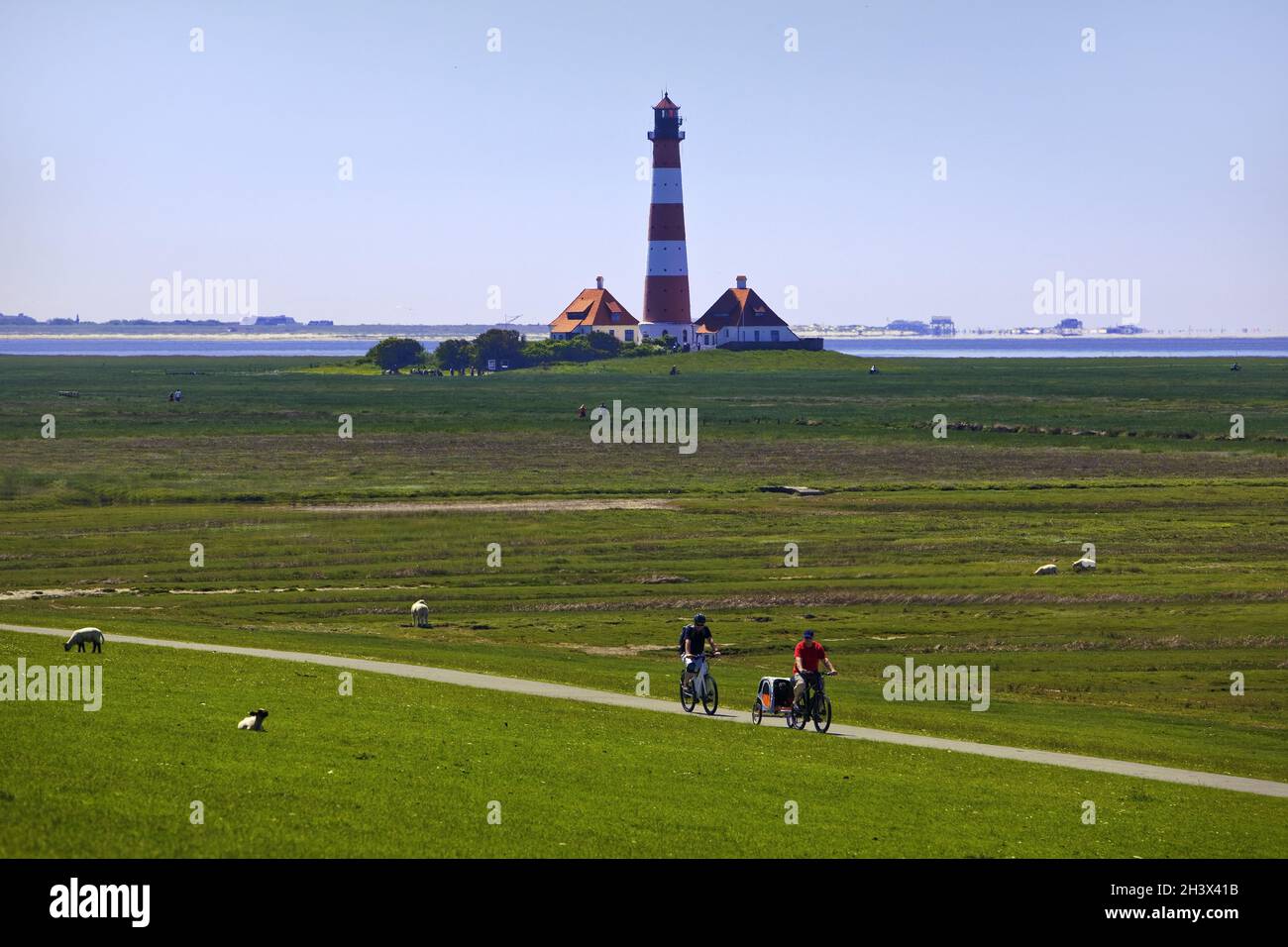 Faro di Westerhever con ciclisti, Parco Nazionale del Mare di Wadden, Frisia settentrionale, Germania, Europa Foto Stock