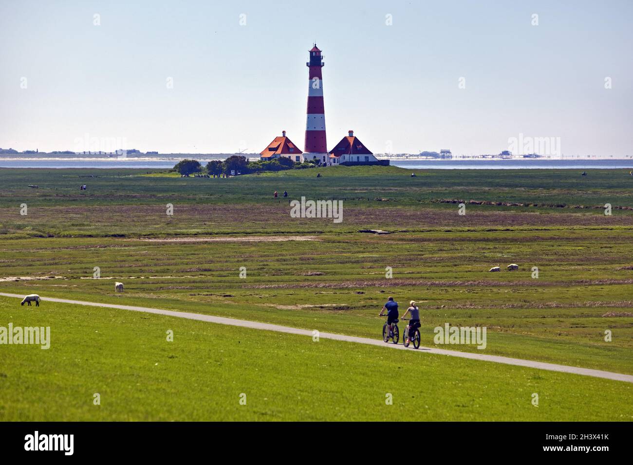 Faro di Westerhever con ciclisti, Parco Nazionale del Mare di Wadden, Frisia settentrionale, Germania, Europa Foto Stock