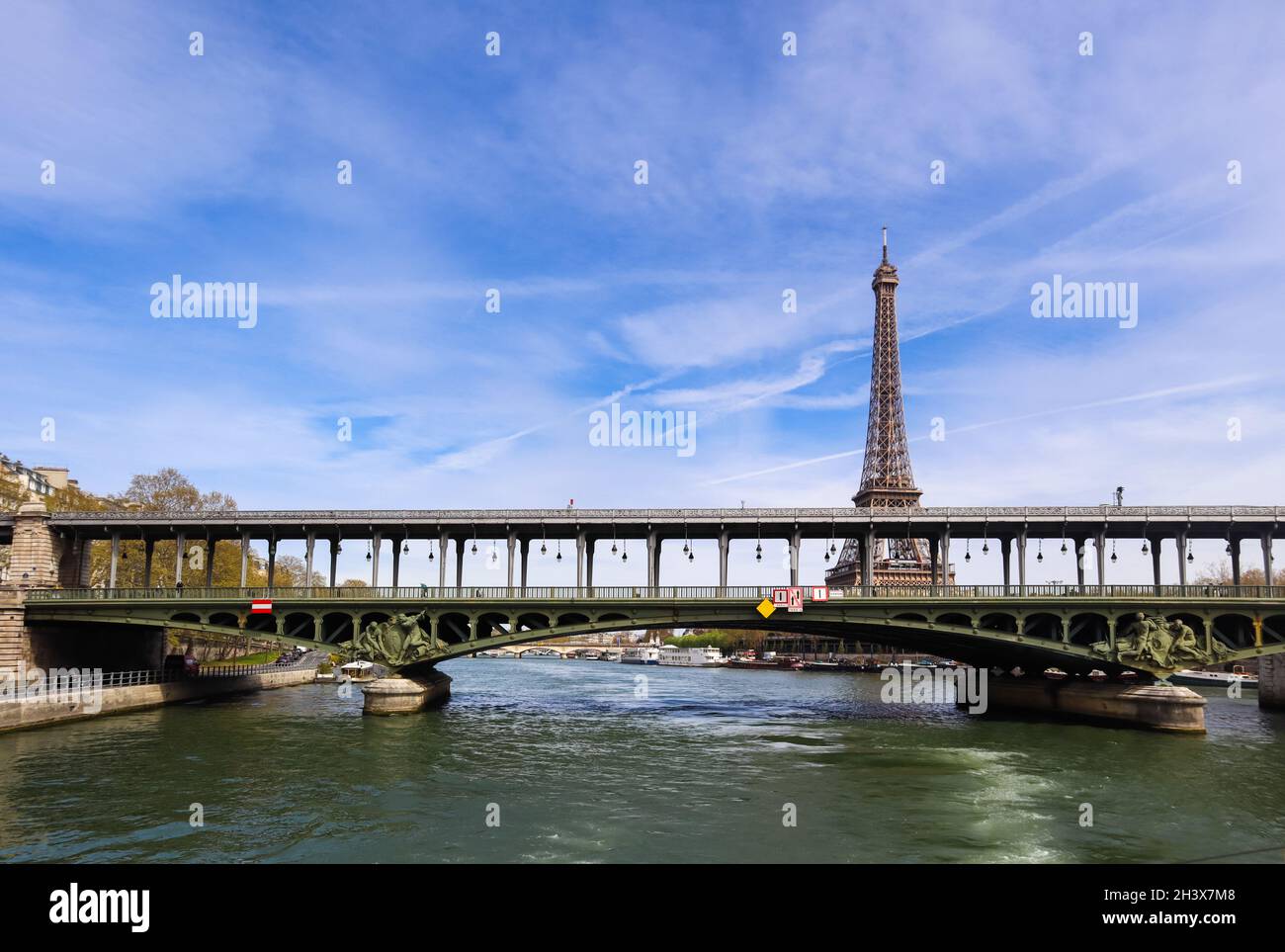 Torre Eiffel contro il cielo blu con nuvole e un ponte sul fiume Senna. Parigi Francia. Aprile 2019 Foto Stock