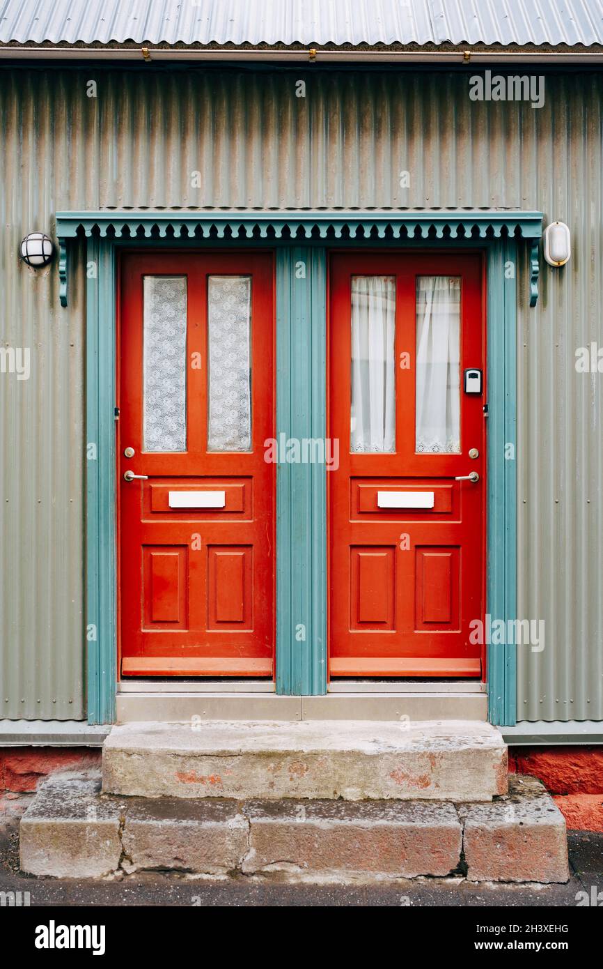 Due porte d'ingresso arancioni con vetro e tende in una porta blu Foto  stock - Alamy