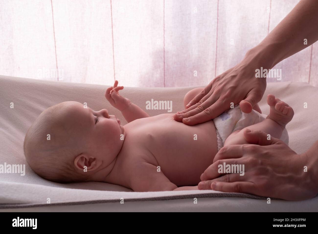 madre massaggiando il ventre del bambino a casa Foto Stock