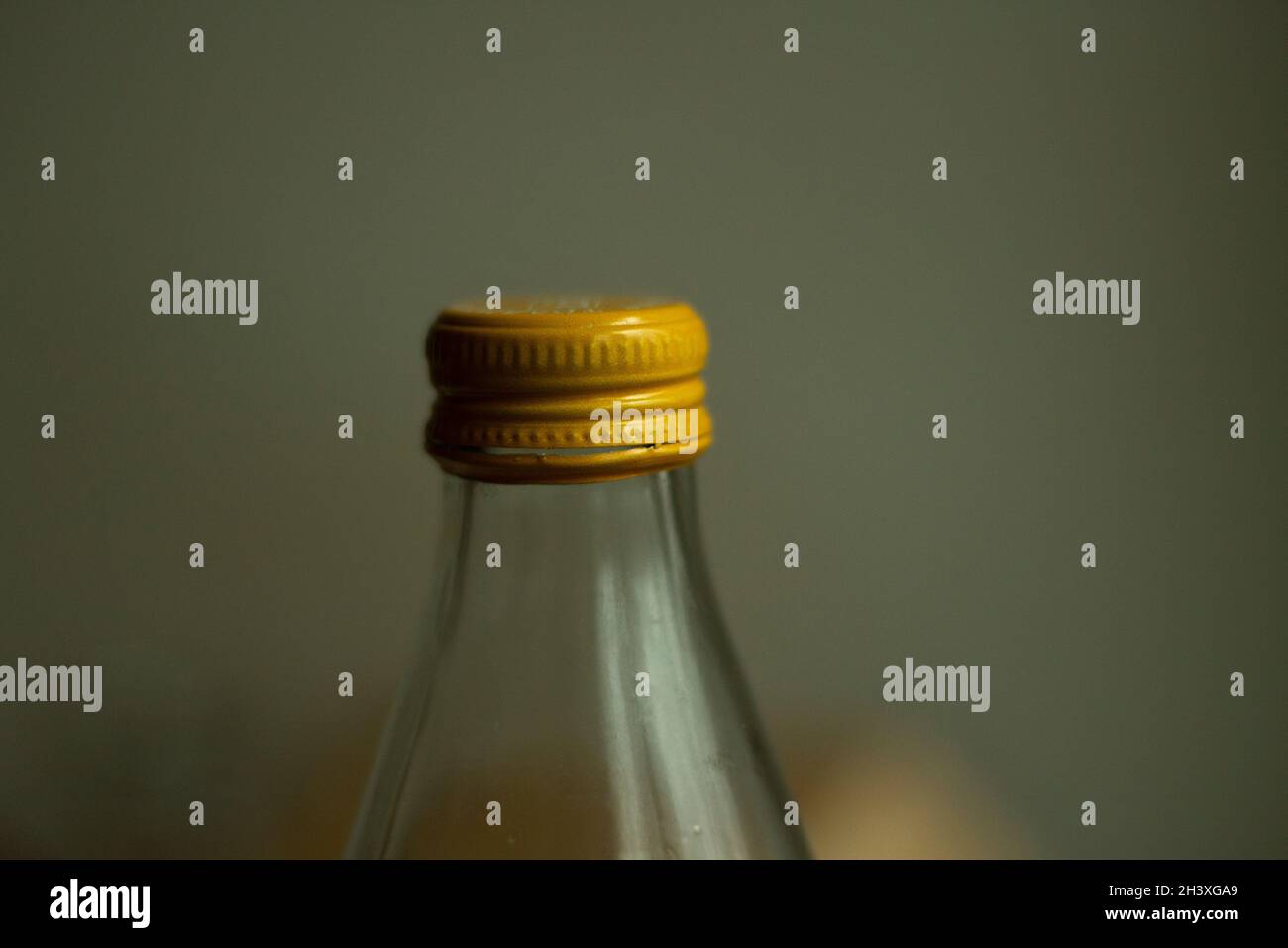 Coperchio giallo su una bottiglia di vetro. Bottiglia d'acqua in vetro. Capsule per conservazione di liquidi. Foto Stock