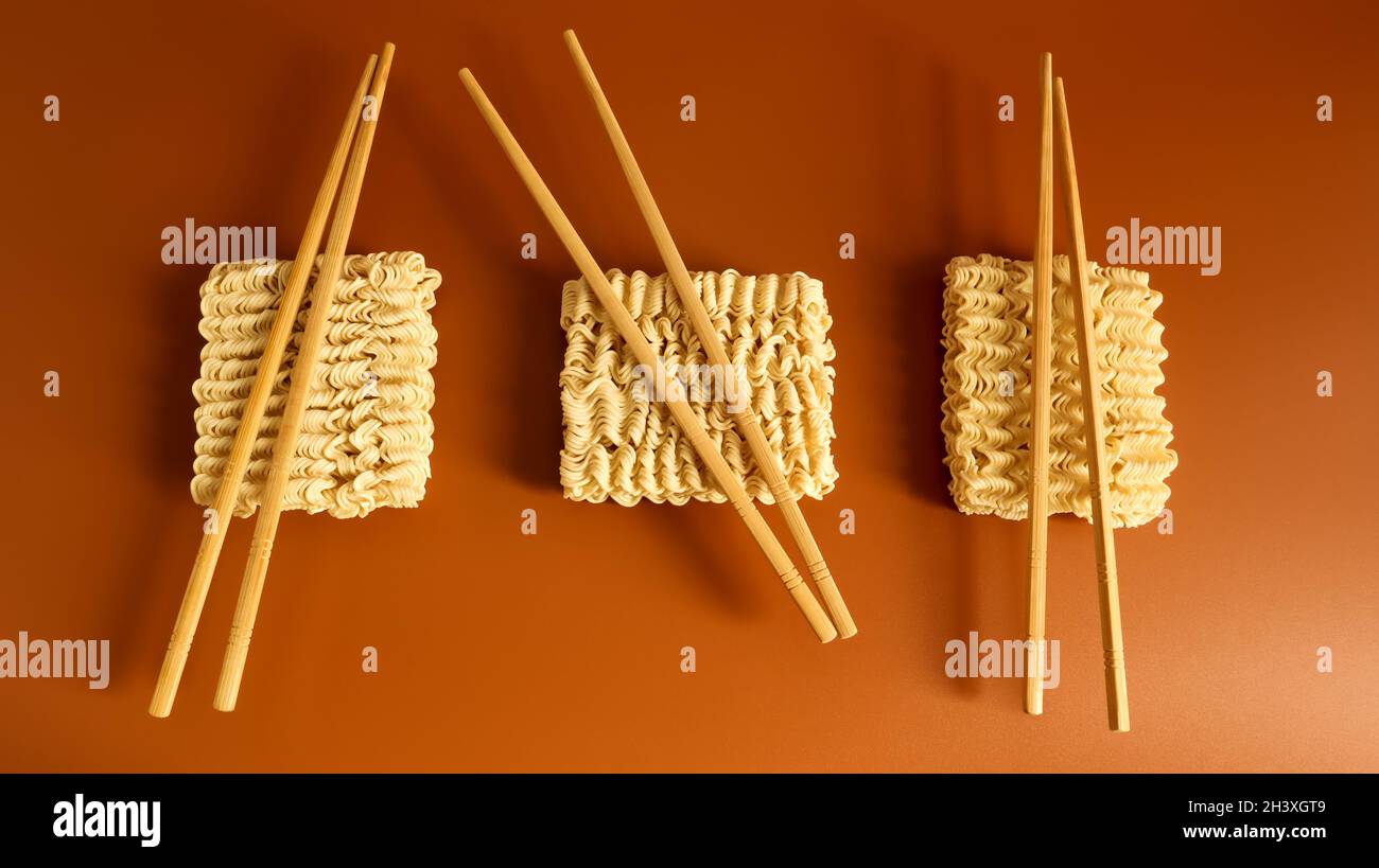 Tagliatelle secche crude con bacchette e spazio di copia. Cibo asiatico, minimalismo, pasta, per la preparazione di cui è eno Foto Stock