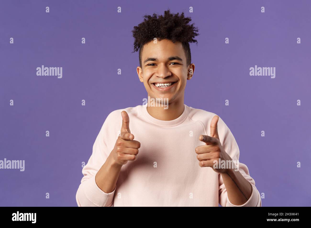 Hai capito. Primo piano ritratto di sorridente simpatico giovane ispanico che dice buona fortuna, puntando le dita verso la fotocamera con piacere cute Foto Stock