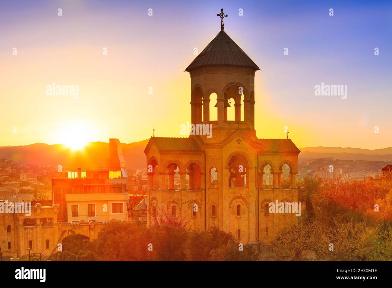 Campanile vicino alla chiesa della Santissima Trinità tramonto panorama a Tbilisi, Georgia Foto Stock