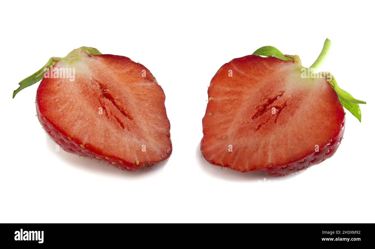 Due metà di fragole isolate su sfondo bianco. Bacche rosse fresche in taglio, messa a fuoco completa. Foto Stock