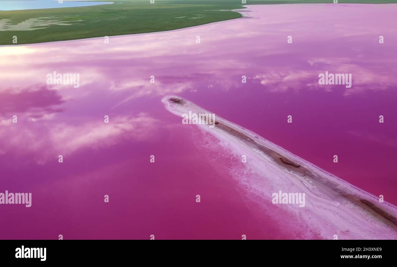Vista aerea di un lago rosa e di un'isola allungata di sale e sabbia. Laghi salini terapeutici con proprietà curative Foto Stock