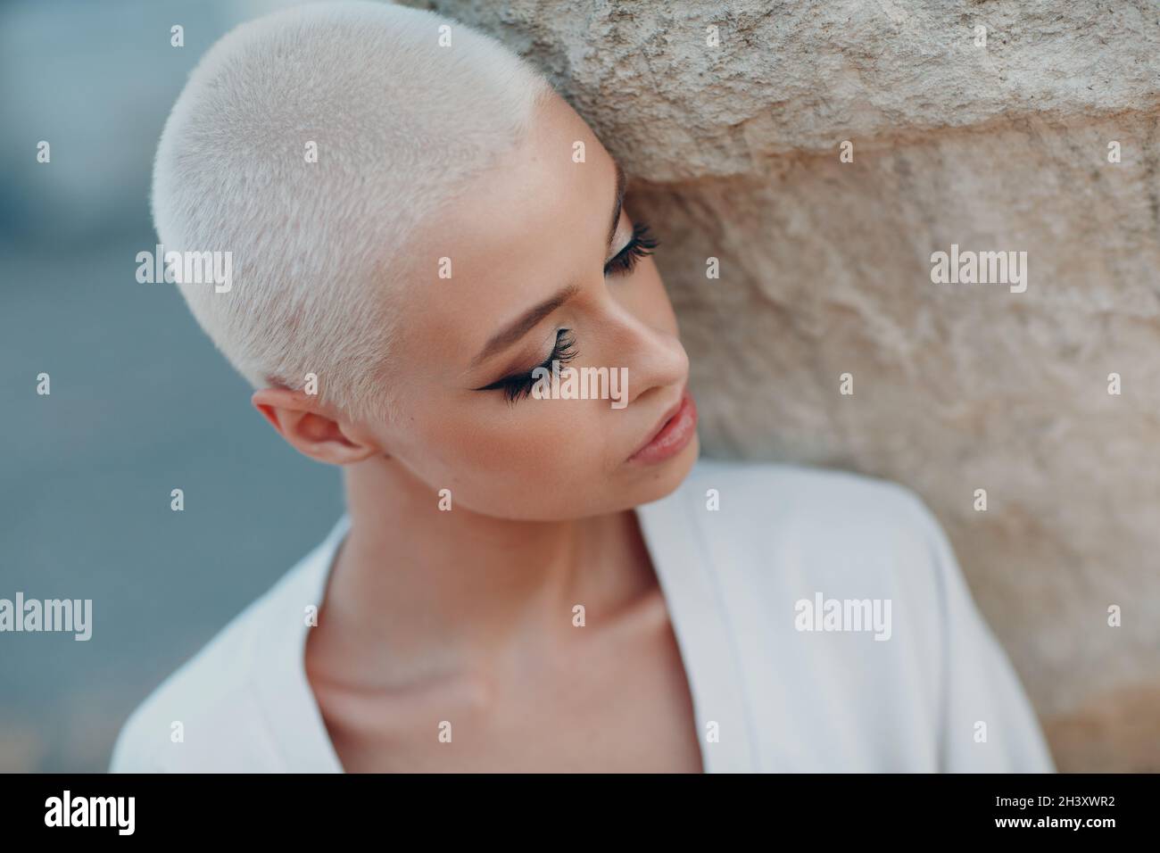 Milleniale giovane donna bionda capelli corti ritratto esterno. Foto Stock