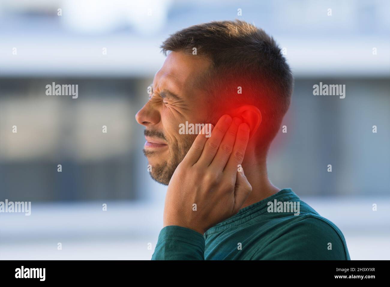 Uomo che soffre di forte dolore all'orecchio o all'orecchio. Otite Foto Stock