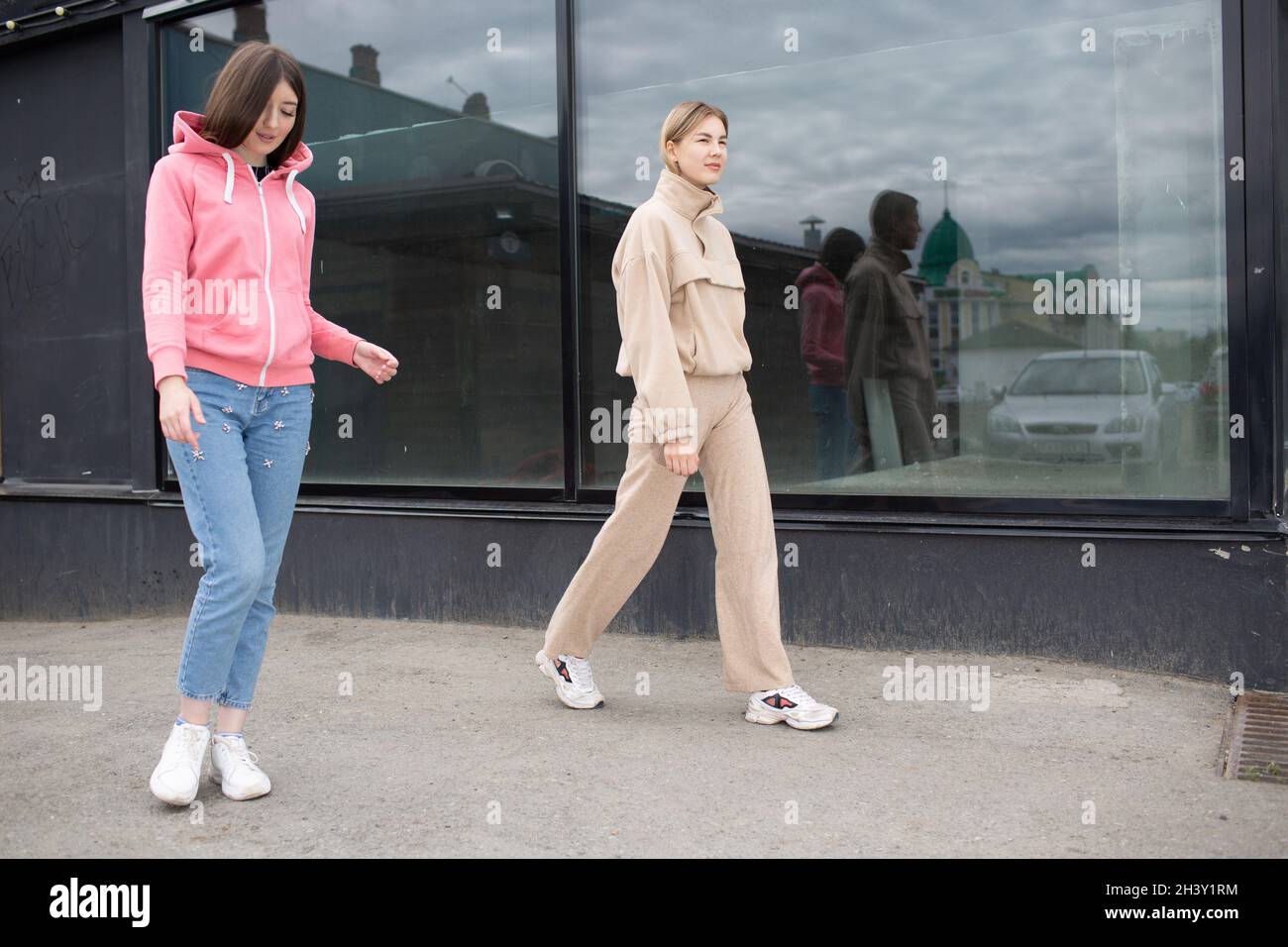 Due ragazze che camminano sulla strada della città. Giovane donna all'aperto. Foto Stock