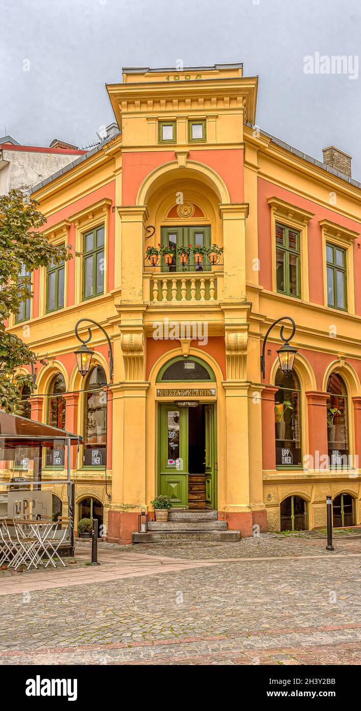 Una bella cituhouse gialla e rossa, sopra la porta è dipinta Gustaf Klarin, l'uomo che aveva un negozio di alimentari a questo indirizzo, Stortorget 8, Ystad, Swe Foto Stock