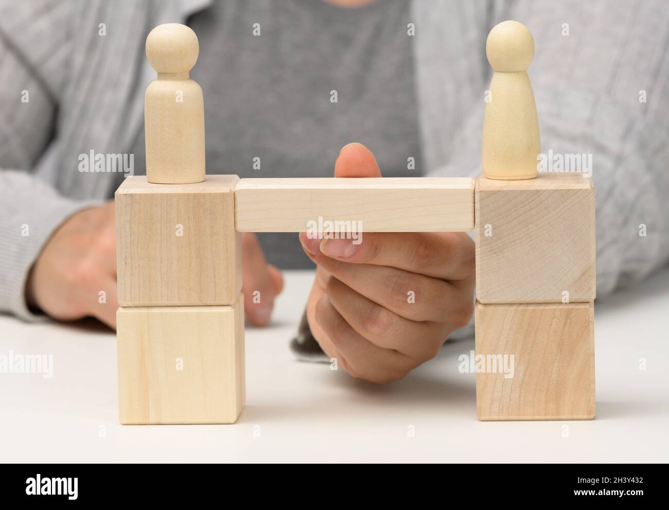 Figure in legno si trovano sul ponte dai lati opposti, concetto di trovare un compromesso, dialogo costruttivo, b Foto Stock