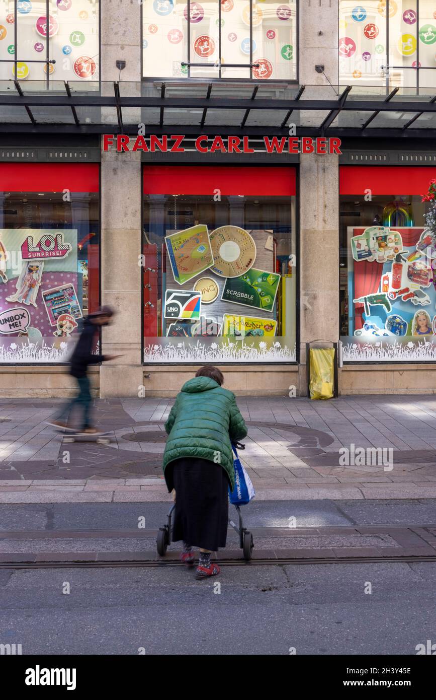Vecchia donna che attraversa strada a piedi e giovani passando sullo skateboard, Rue de la Croix-d'Or 12, 1204 Ginevra, Svizzera Foto Stock