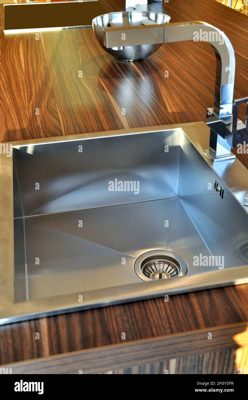 Interno di lussuosa cucina moderna e lavandino, rubinetto e scarico in acciaio inossidabile Foto Stock