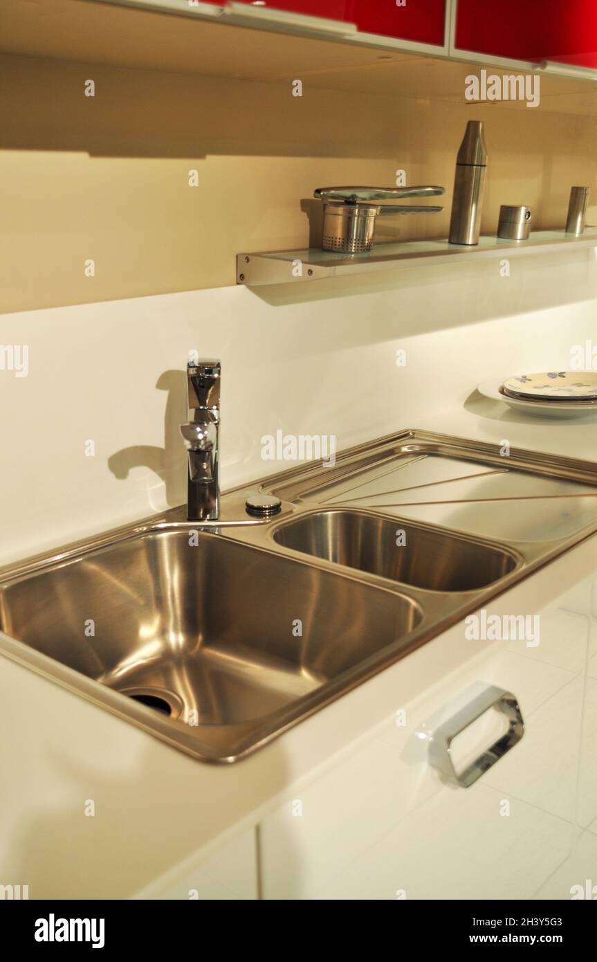 Interno di lussuosa cucina moderna e lavandino, rubinetto e scarico in acciaio inossidabile Foto Stock