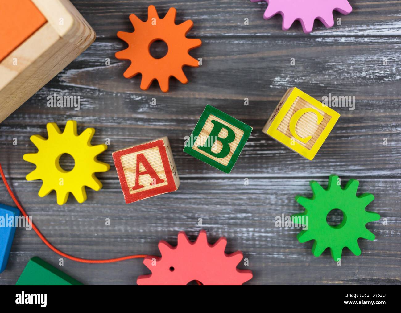 Frazioni multicolore, blocchi, giocattoli su un tavolo di legno grigio. Ritorno a scuola, matematica divertente, giochi per l'asilo, istruzione prescolare. Foto Stock