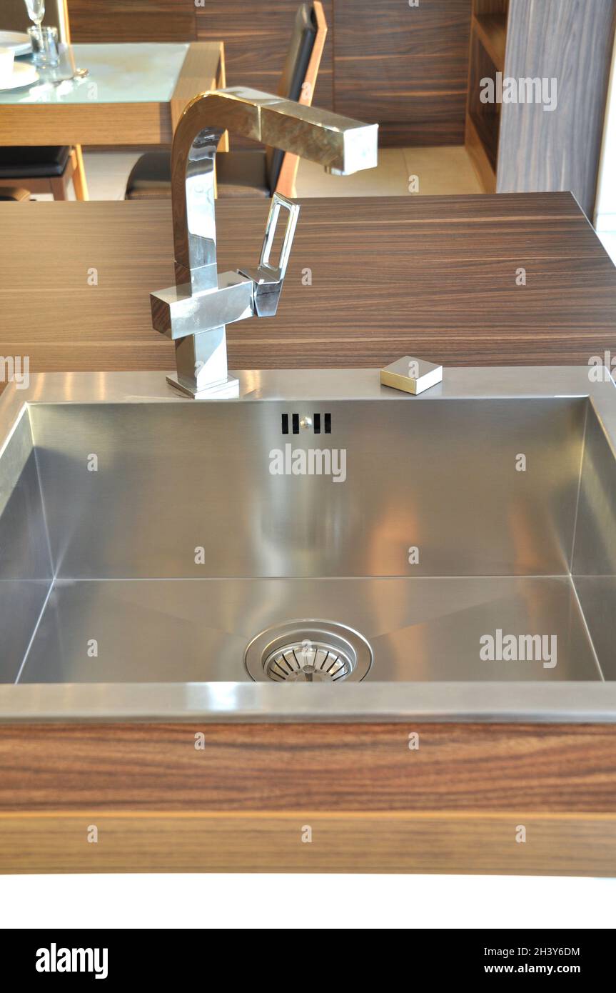 Interno di lussuosa cucina moderna e lavandino, rubinetto e scarico in acciaio inossidabile Foto Stock