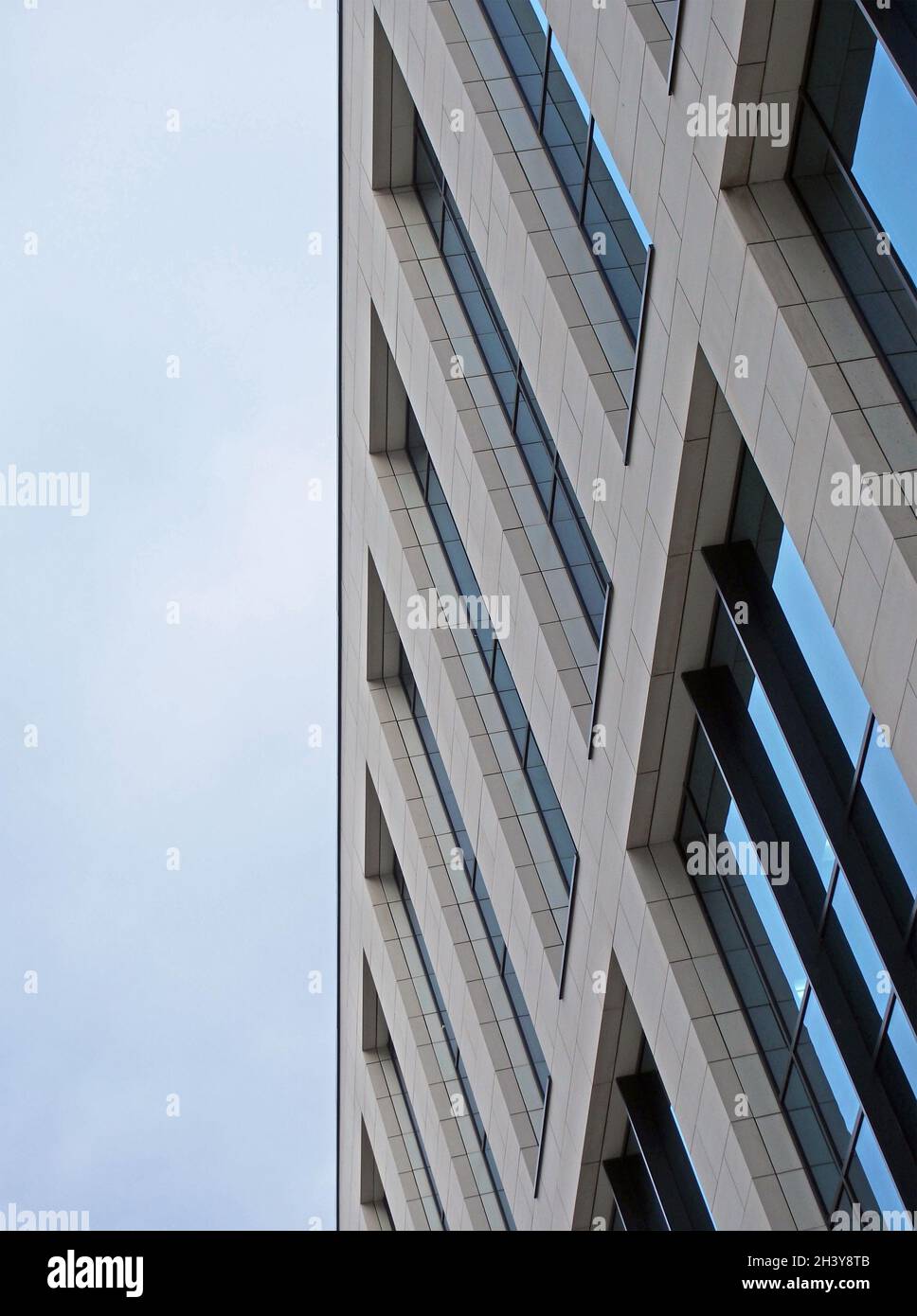 Vicino ad un moderno edificio di uffici con cielo nuvoloso blu Foto Stock