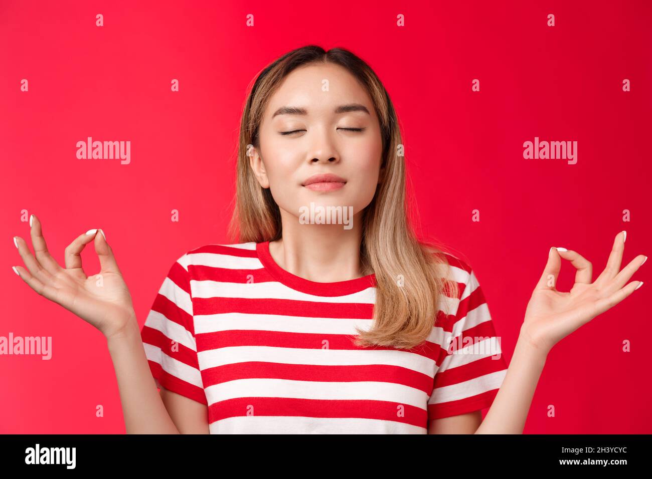 Ragazza sensazione zen. Cute asian ragazza meditating unire con la natura, occhi vicini respirare mani di presa profonda sollevata lotus nirvana posa, Foto Stock