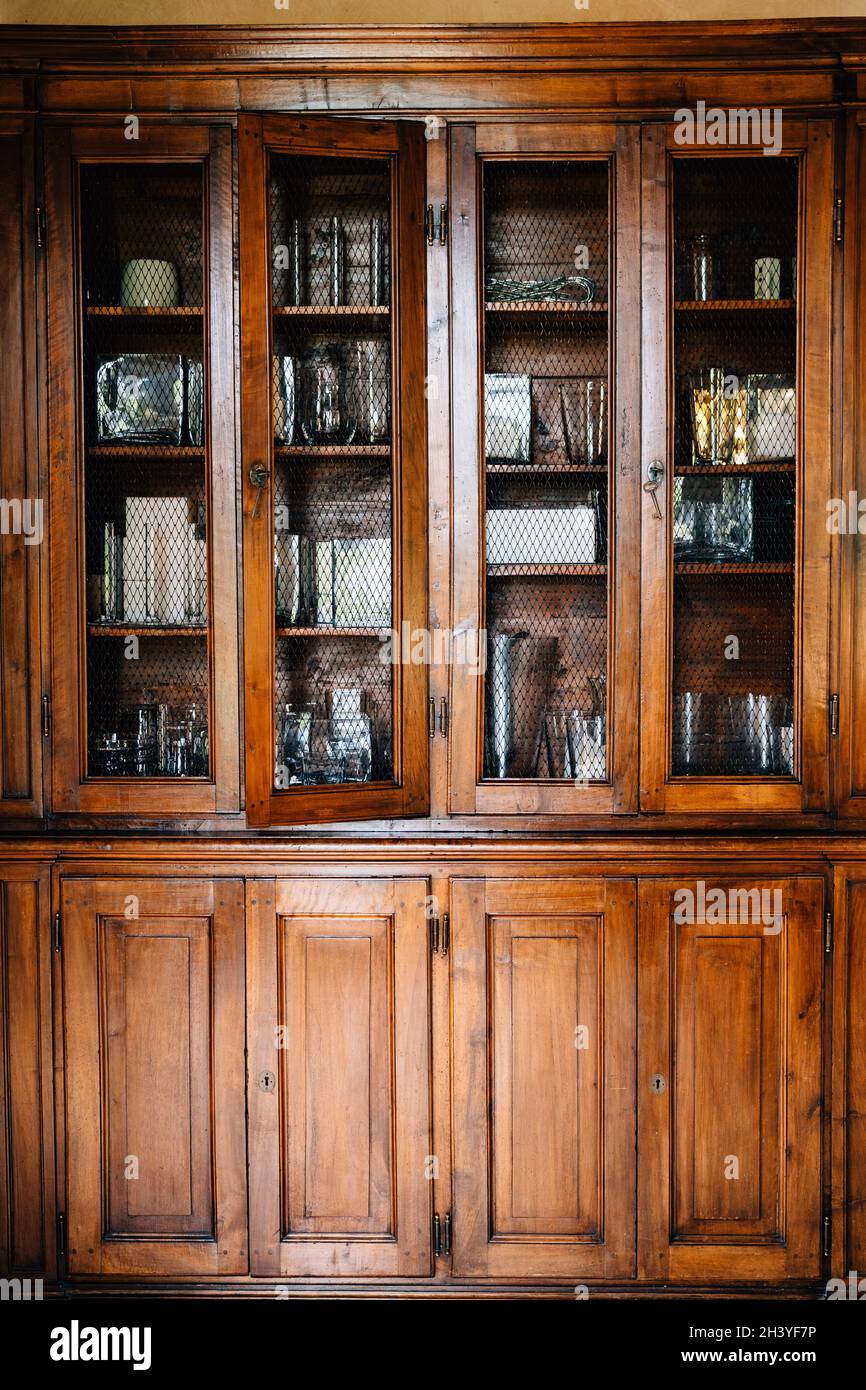 Un vecchio armadio di legno con porte che possono essere chiuse con chiavi e una grata poco profonda per il vetro. Foto Stock
