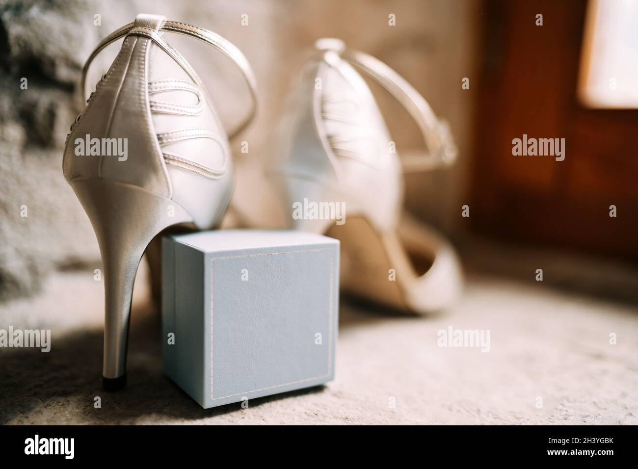 Primo piano di un ring box con scarpe bianche da sposa in una stanza con  profondità di campo poco profonda Foto stock - Alamy