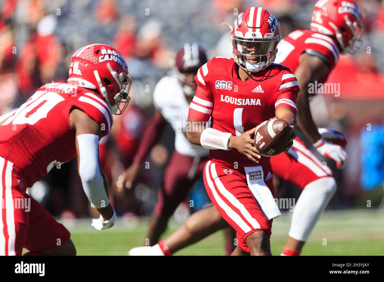 Louisiana-Lafayette Ragin Cajuns quarterback Levi Lewis (1) cerca di consegnare la palla alla Louisiana-Lafayette Ragin Cajuns che torna indietro Terrence Willi Foto Stock