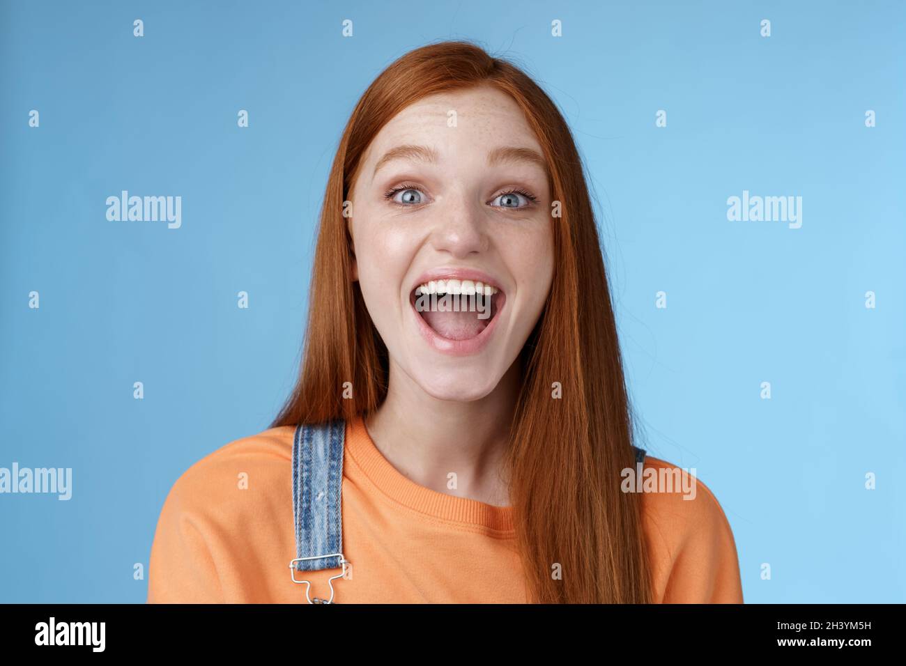 Divertente carismatico vivace ginger ragazza uscente entusiasta di divertirsi amici urlare dire un mostrando perfetto sorriso bianco godere di frien Foto Stock