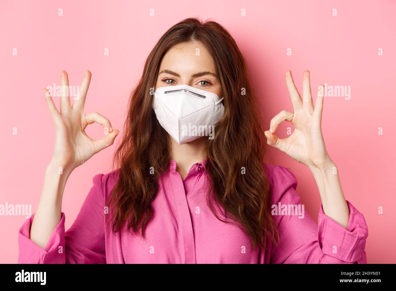 Coronavirus, misure preventive e concetto di salute. Primo piano ritratto di buona donna indossa il suo respiratore medico da c Foto Stock
