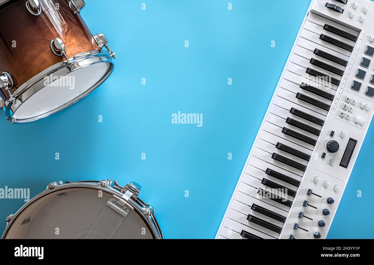 Tasti musicali e tamburi su sfondo blu, disposizione piatta, spazio copia. Foto Stock