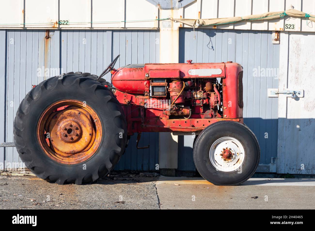 Il trattore di Nuffield è parcheggiato di fronte ai capannoni della spiaggia di Titahi Bay, Porirua, Wellington, Isola del Nord, Nuova Zelanda Foto Stock