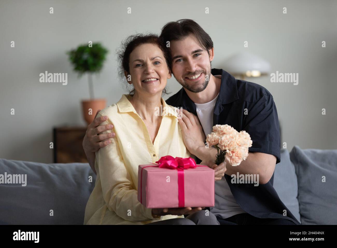 Ritratto di famiglia di legame seduto sul divano con regali. Foto Stock