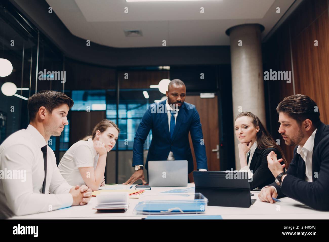 Il team di uomini d'affari e donne d'affari durante la riunione d'ufficio. La discussione di conferenza di gruppo della gente di affari si siede al tavolo con l'uomo del capo e. Foto Stock