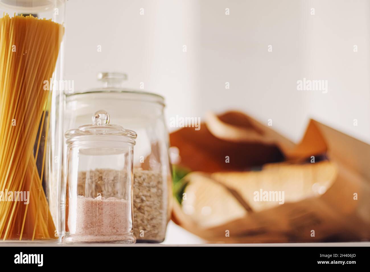 Prodotti alimentari in vasetti di vetro in cucina, pasta, cereali, sale, vino, generi alimentari Foto Stock