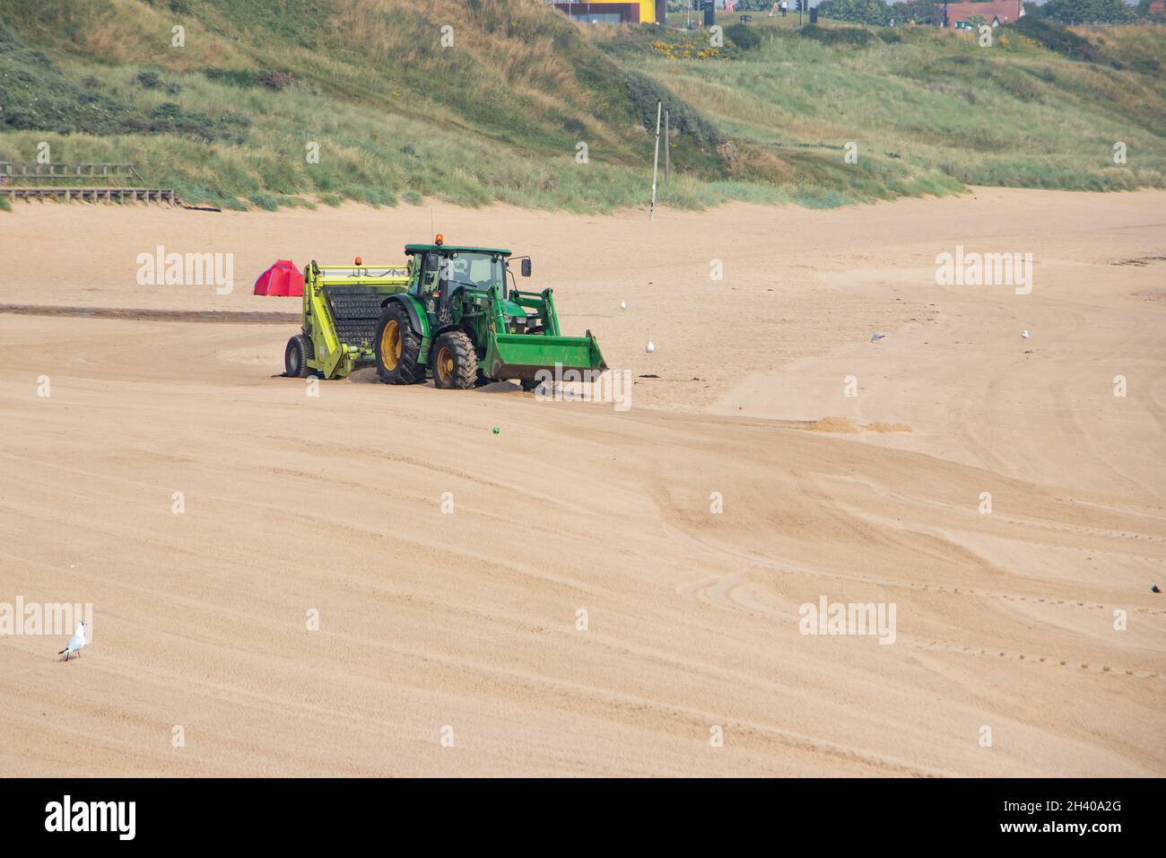Vista della spiaggia di Tynemouth e trattore che combatte la spiaggia Tyne & Wear Foto Stock