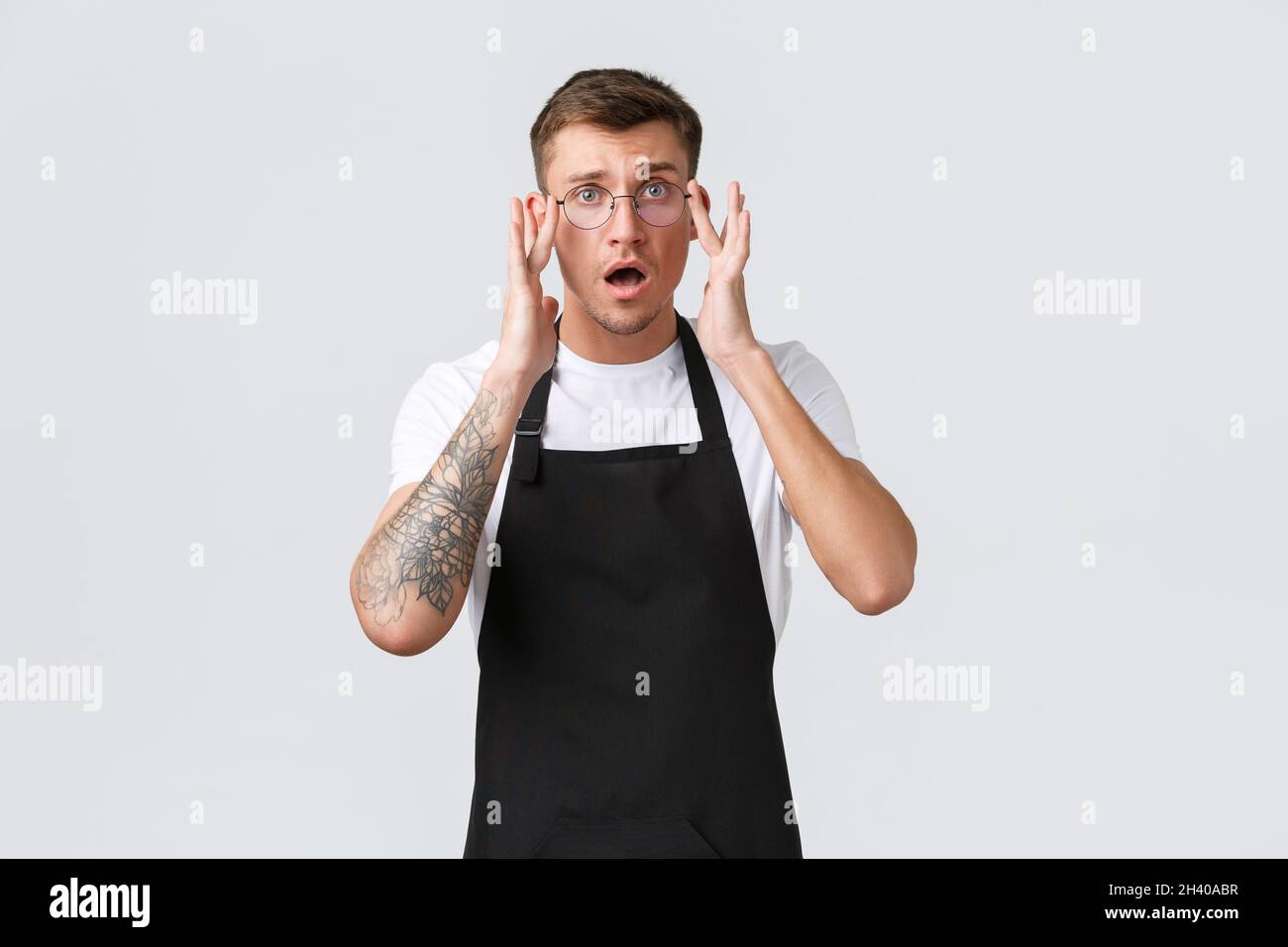 Concetto di proprietari di piccole aziende al dettaglio, dipendenti di caffè e ristoranti. Preoccupato e confuso carino barista, cameriere messo su occhiali, o Foto Stock