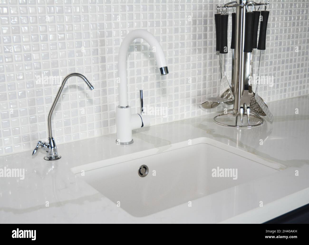 Moderno lavandino in ceramica bianca. Cucina moderna rubinetto cromato e muro di piastrelle mosaico Foto Stock