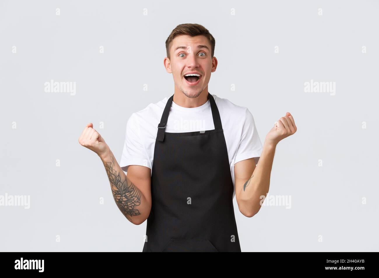 Dipendenti, negozi di alimentari e caffè concetto. Buon e sollievo sorridente barista bello, cameriere in grembiule nero, pompa pugnale Foto Stock