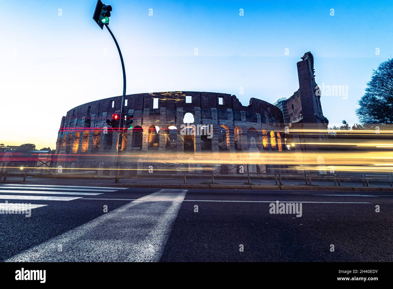 Colosseo di notte Roma Italia con luci a lunga esposizione. Traffico in rapido movimento, autobus. Foto Stock