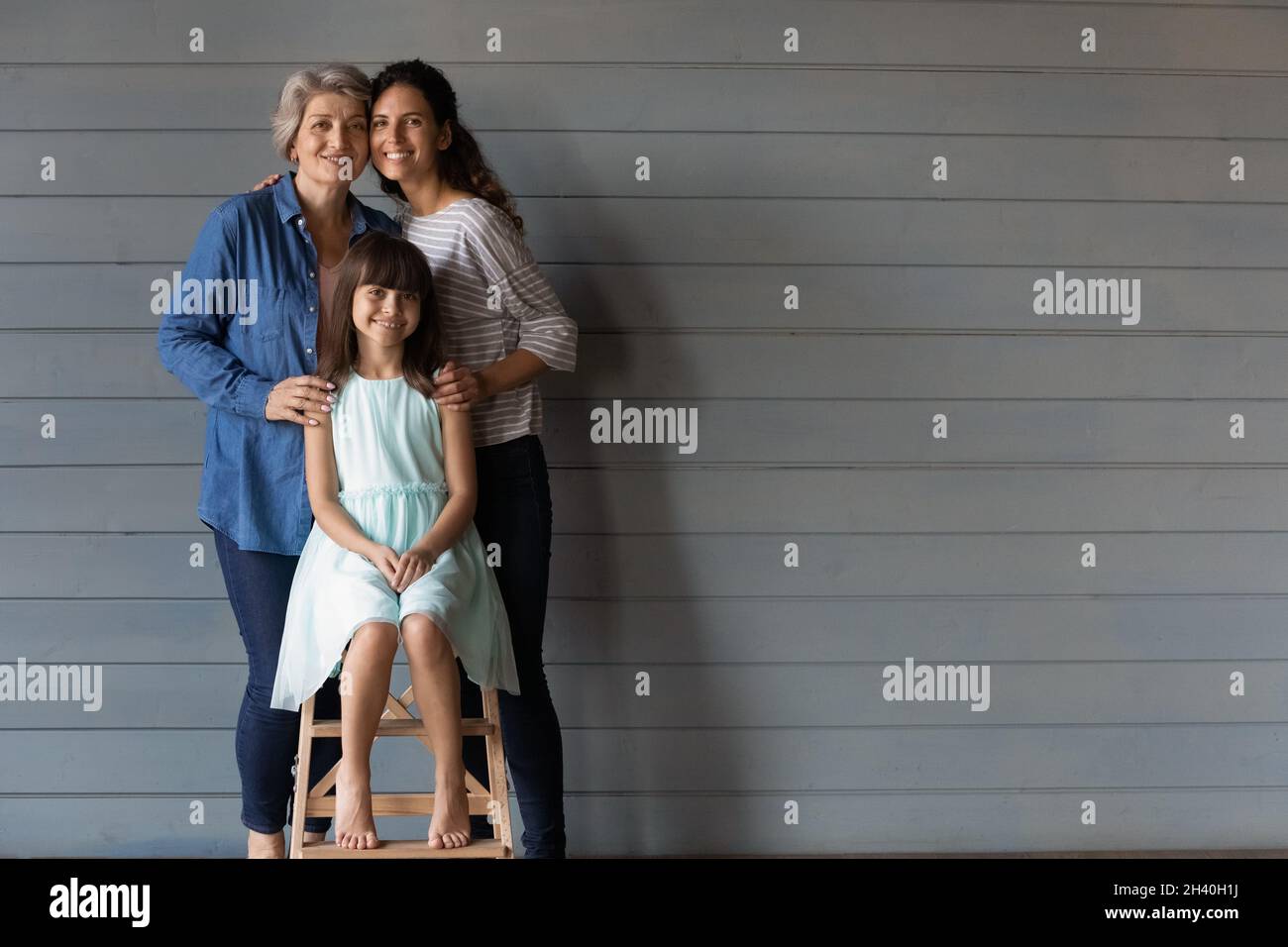Felice famiglia ha collegato le donne e capretto che abbraccia con amore, cura Foto Stock