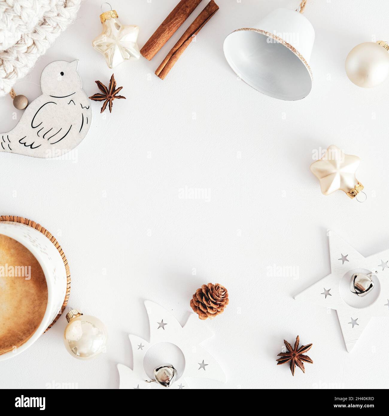 Composizione per le vacanze invernali con tazza di cioccolata calda, bastoncini di cannella, decorazioni nordiche su un tavolo da scrivania bianco. Estetica nordica e scandinava. Igge, Foto Stock