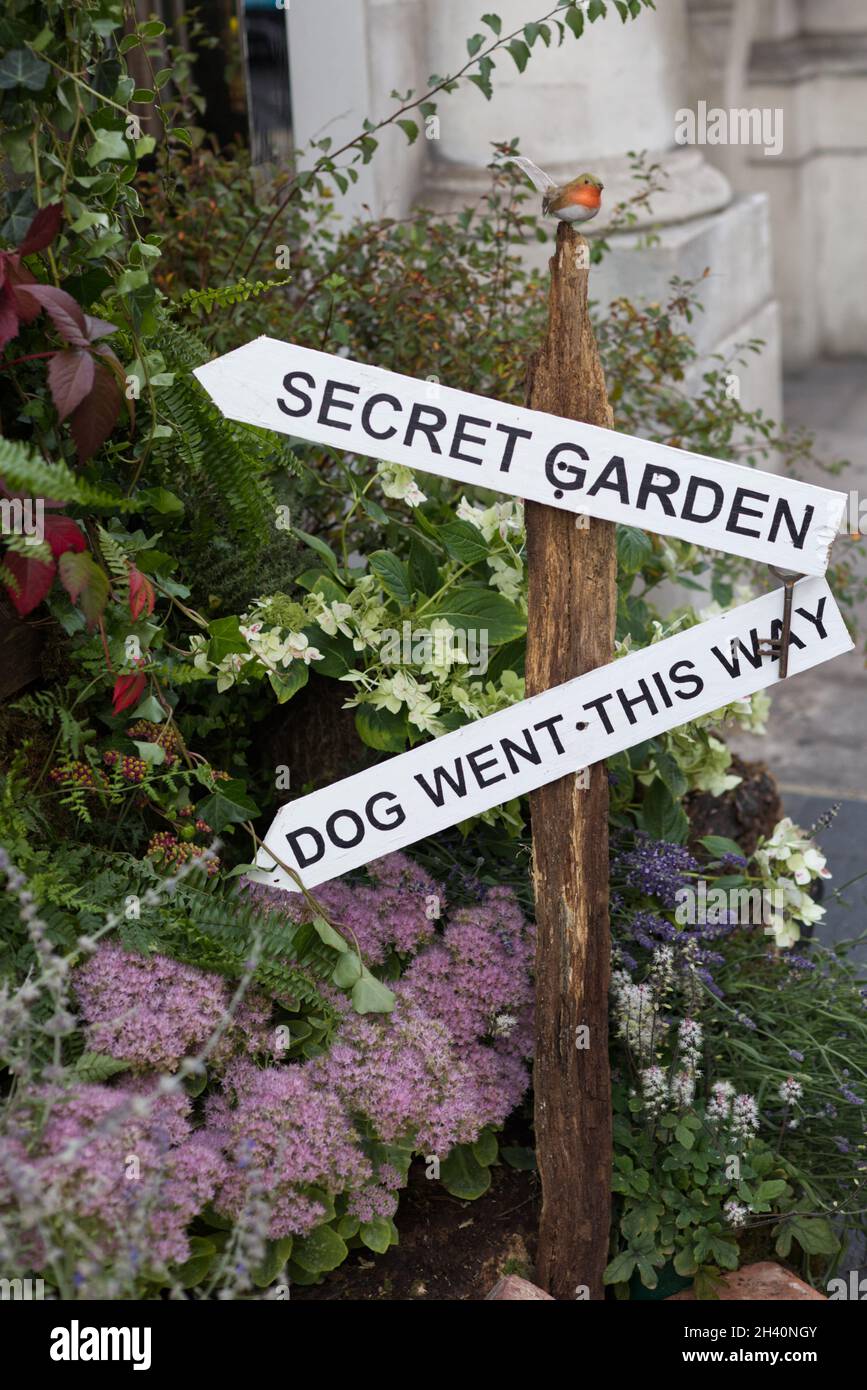 segno che dirige la gente al giardino segreto ed il cane è andato questo senso Foto Stock