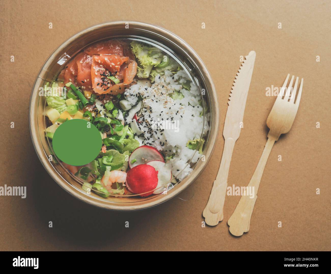 Insalata sana con salmone in confezione ecologica di carta artigianale con posate in legno. Consegna di alimenti senza plastica. Vista dall'alto. Foto Stock