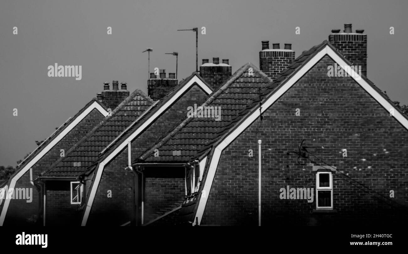 Una vista laterale di una fila di tetto in stile olandese Gambrell bable finisce in bianco e nero nel Lincolnshire. Foto Stock