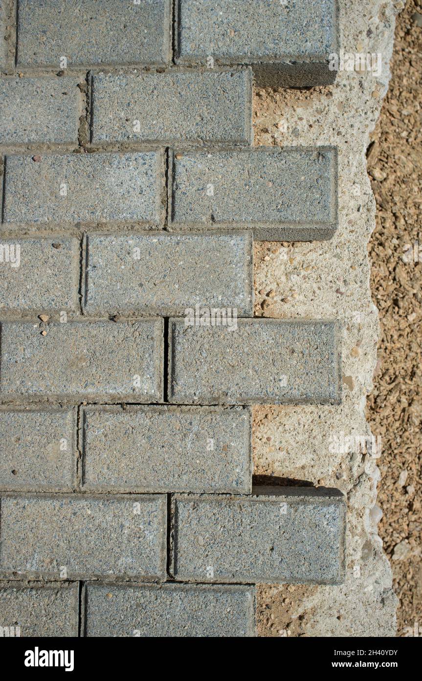 Pavimentazione in cemento acciottolato in costruzione. Posa di pezzi di pavimentazione interbloccanti Foto Stock