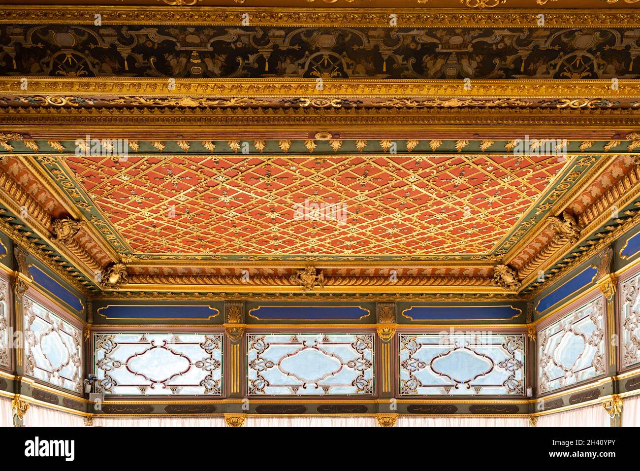 ISTANBUL, TURCHIA - 9 AGOSTO 2021: Soffitto interno decorato di lusso del padiglione ottomano nel Palazzo Topkapi con divani e grandi finestre Foto Stock