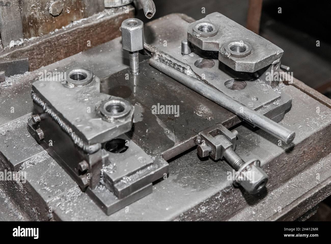 Processo e sistema, attrezzatura e utensile per la lavorazione dei metalli con meccanismi di fissaggio per la foratura del ferro con tubo per l'acqua di raffreddamento nell'officina di un i Foto Stock