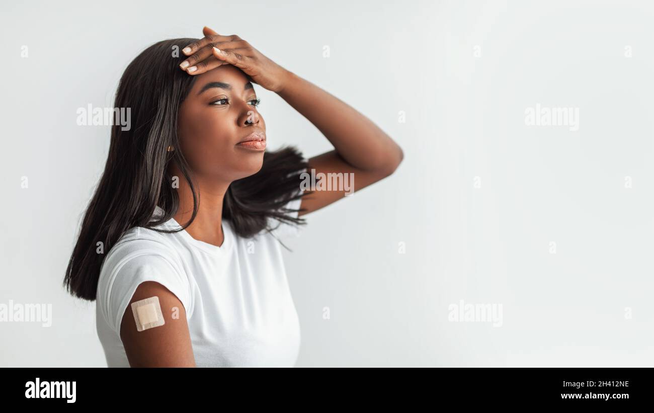 Donna nera che soffre di febbre dopo il vaccino Foto Stock