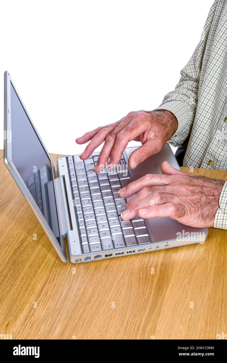 Ritratto verticale di un anziano Signore che naviga su Internet sul suo computer portatile su sfondo bianco. Foto Stock