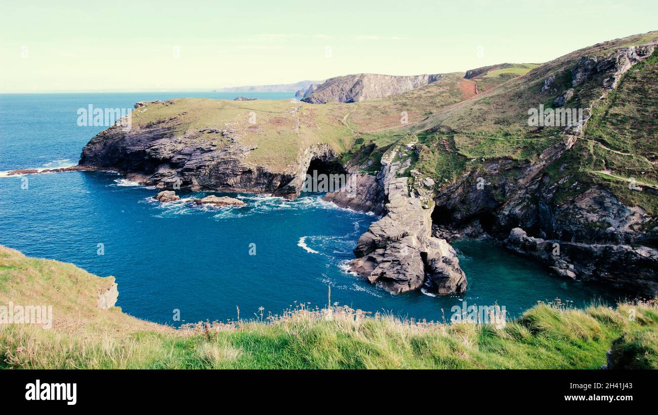 Lungo la costa della Cornovaglia, con la grotta di Merlin a Tintagel, associata alla leggenda di Re Artù. Foto Stock