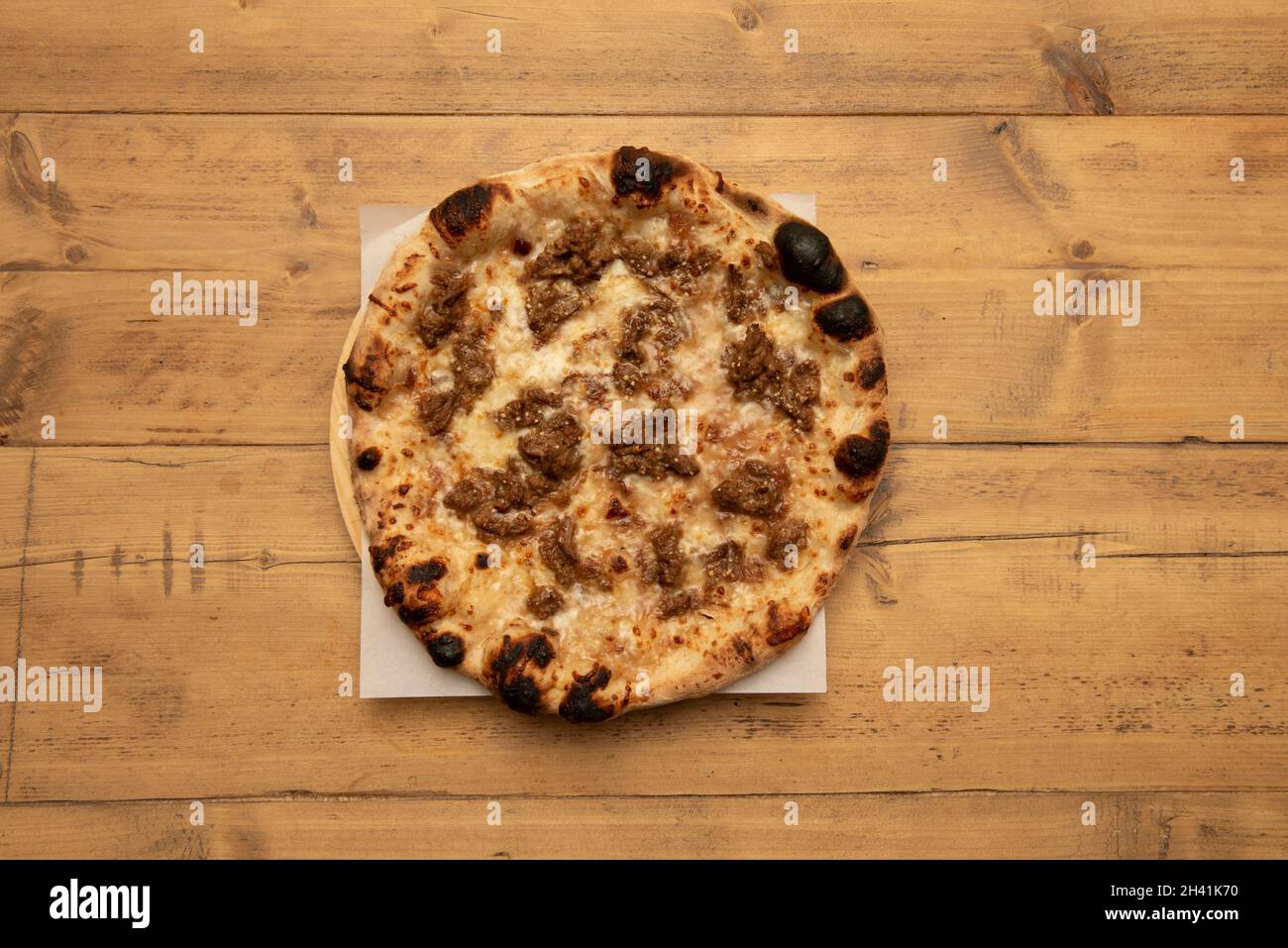 Pizza fatta in casa con pasta di farina di grano con stufato di carne di cinghiale e mozzarella Foto Stock